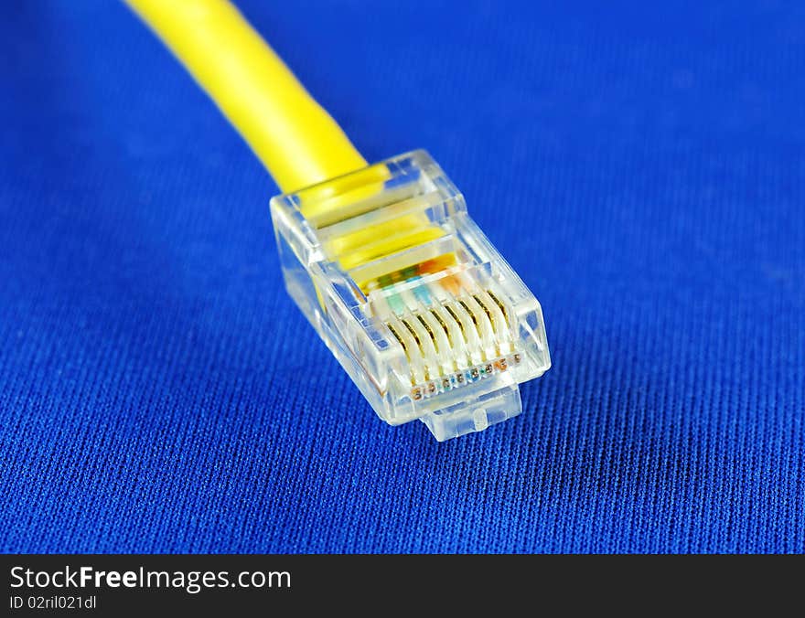 Close-up view of the yellow Ethernet (RJ45) cable isolated on blue