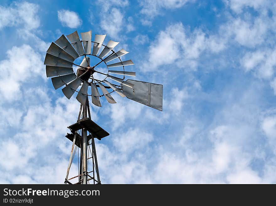 Old Metal Windmill Against Cloudy Sky