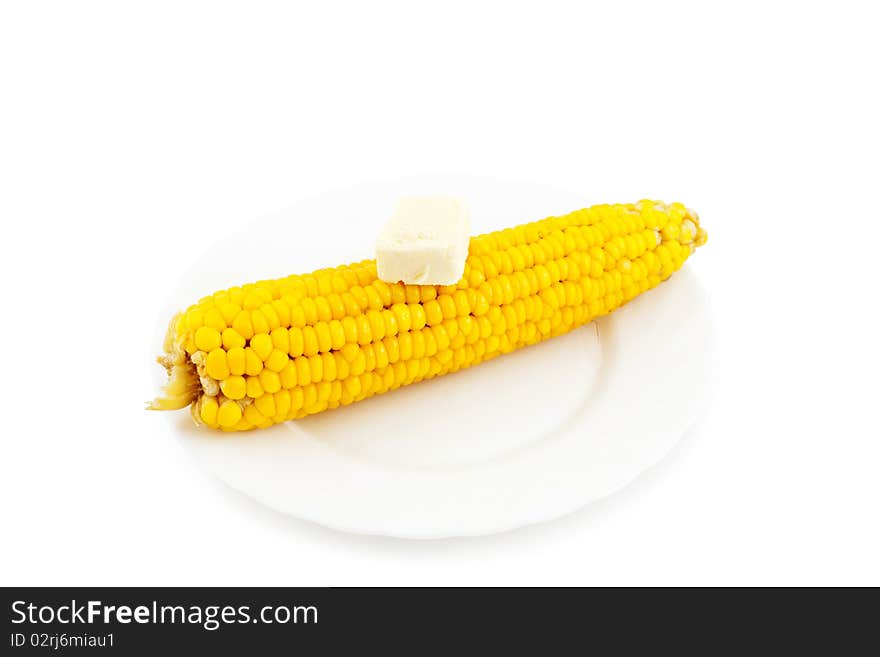 Boiled corn with a piece of butter on plate.