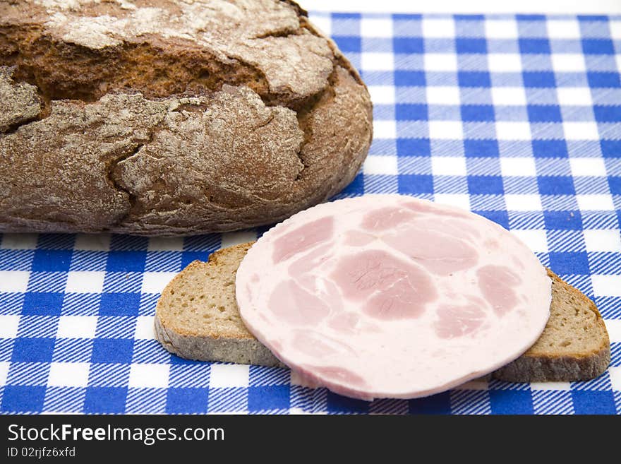 Sausage and bread onto blue-white table cloth