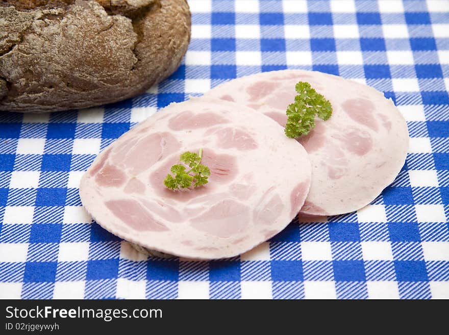 Sausage and bread onto blue-white table cloth