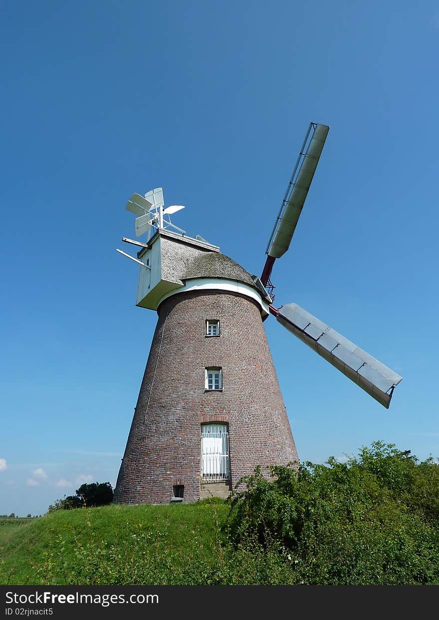 An old, but still working, so-called Towermill in Germany. The top of this windmill is fitted with a cap which can be turned to bring the sails in the wind. An old, but still working, so-called Towermill in Germany. The top of this windmill is fitted with a cap which can be turned to bring the sails in the wind.