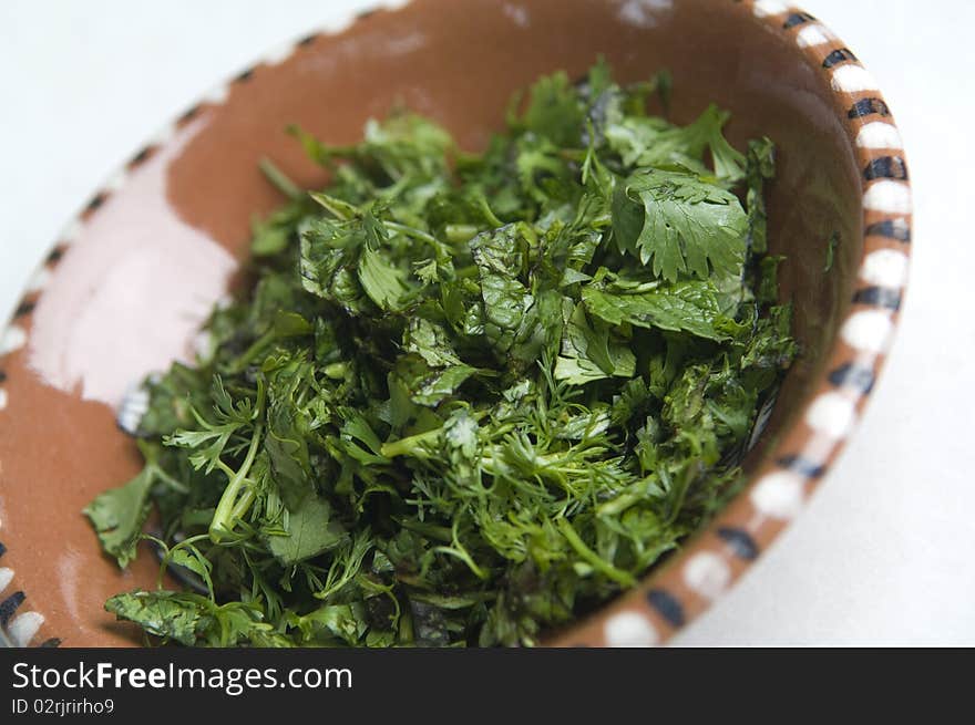 Green herbs in a bowl isolated on white