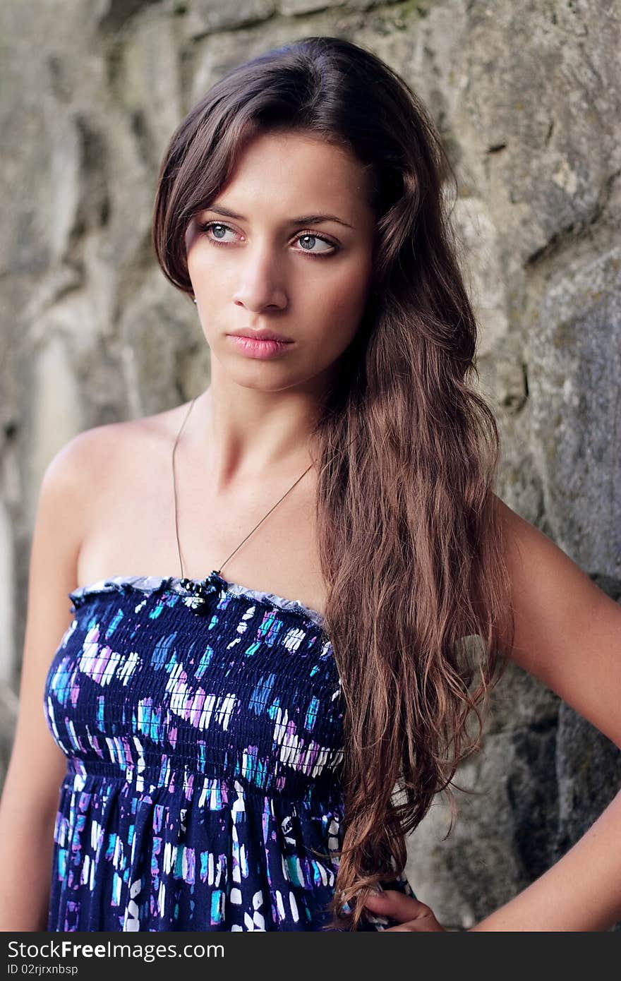 Beautiful young girl standing at the wall