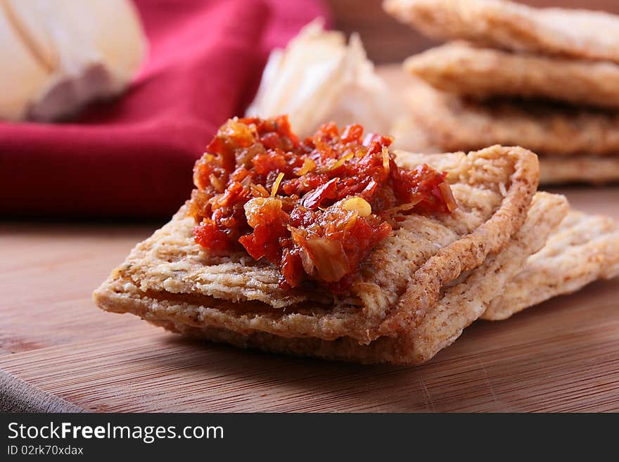 Wheat crackers on a kitchen board with a hot spice. Wheat crackers on a kitchen board with a hot spice.