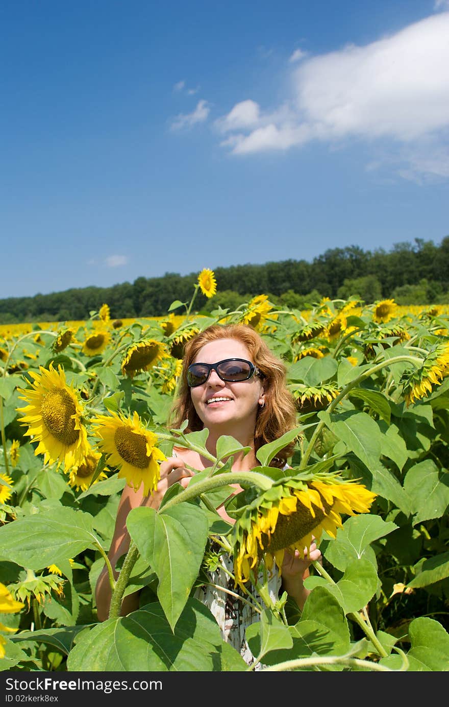 The beautiful woman in the field of sunflowers