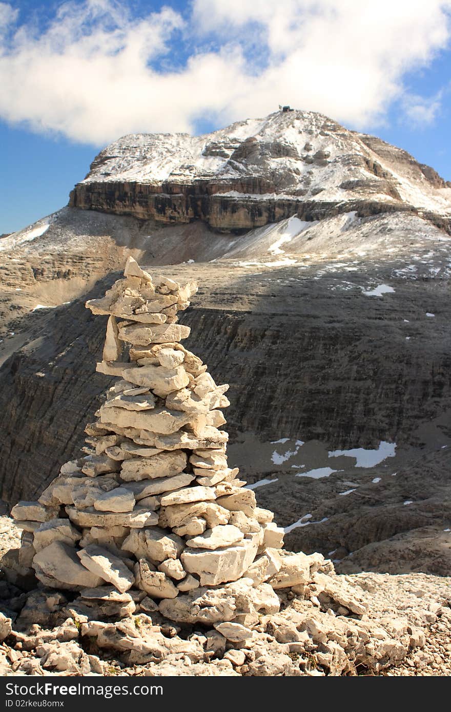 A view of the mountain summit of Piz Boa in the Italian Dolomites with a rock cairn in the foreground. A view of the mountain summit of Piz Boa in the Italian Dolomites with a rock cairn in the foreground