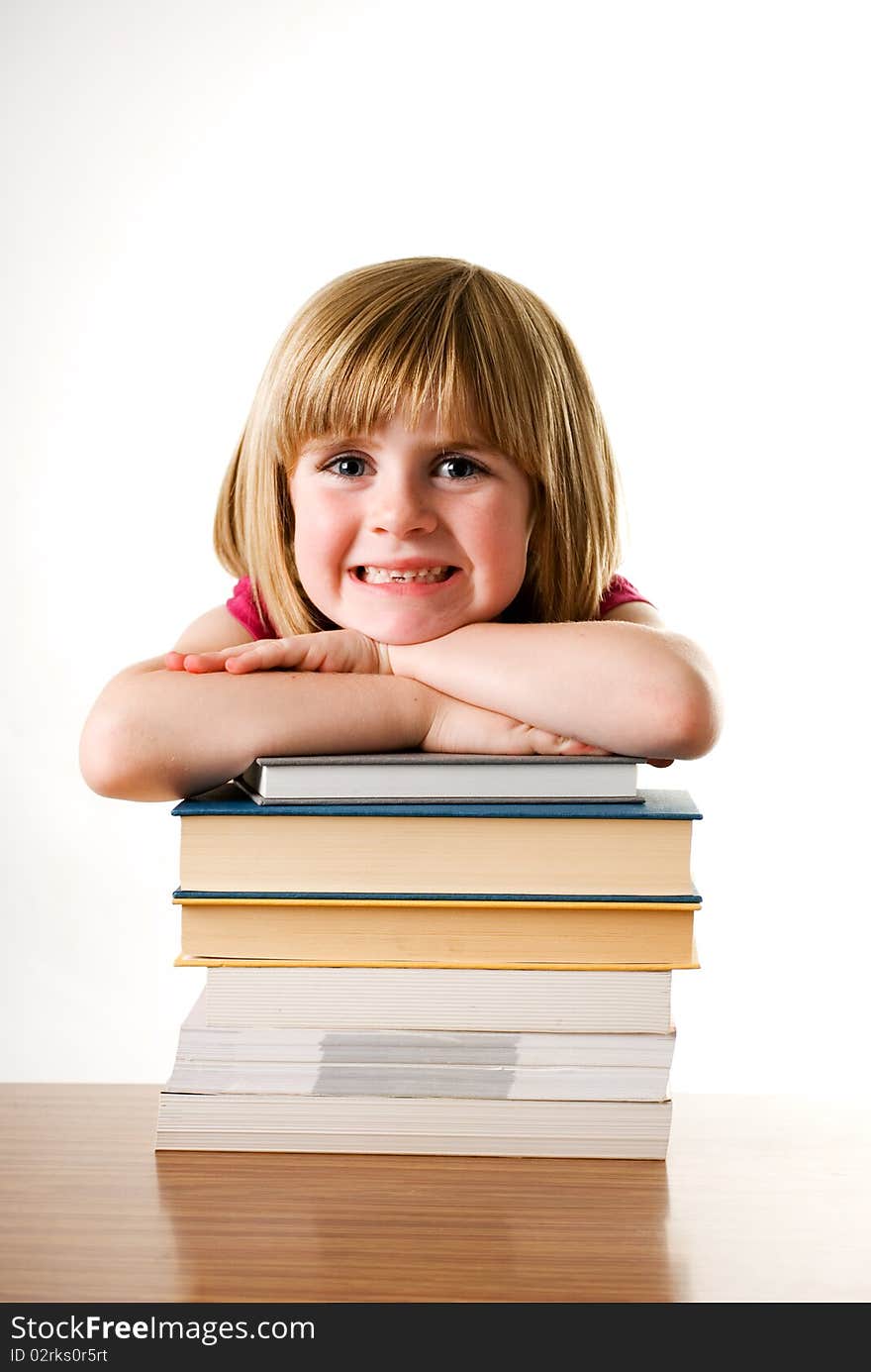 Young girl leaning on a stack of books and smiling