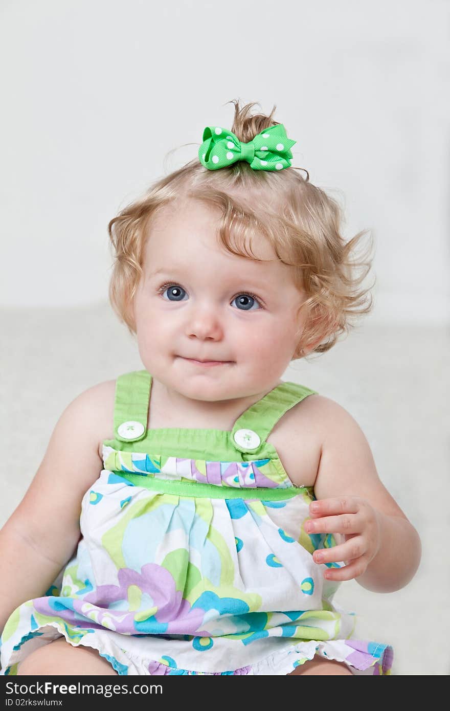 Portrait of happy one year old baby sitting on floor