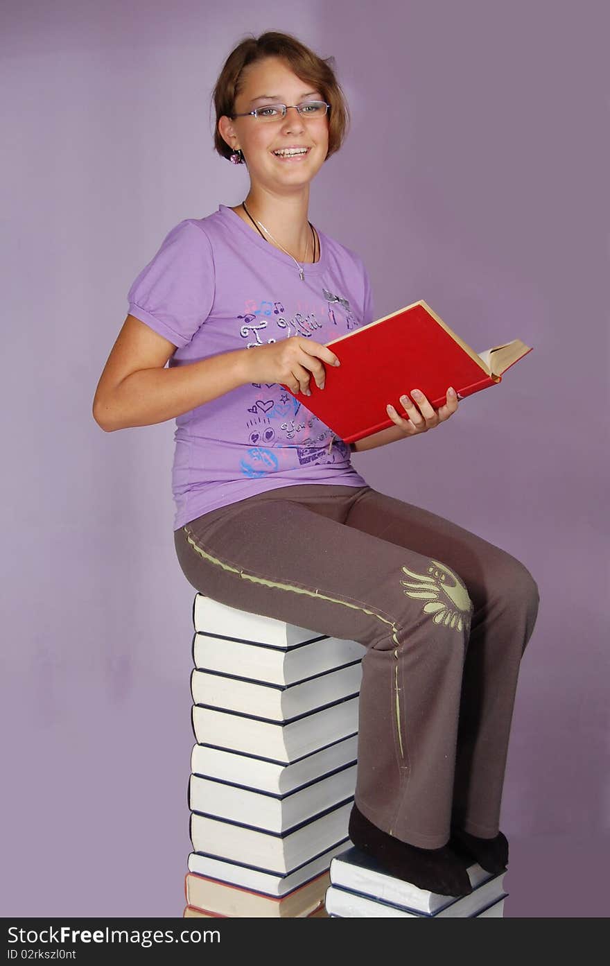 The girl reads on some books. The girl reads on some books