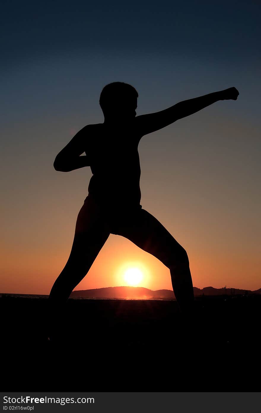 Boy doing exercise at sunset on beach. Boy doing exercise at sunset on beach