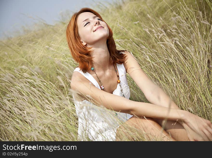 Beautiful red-haired girl at grass