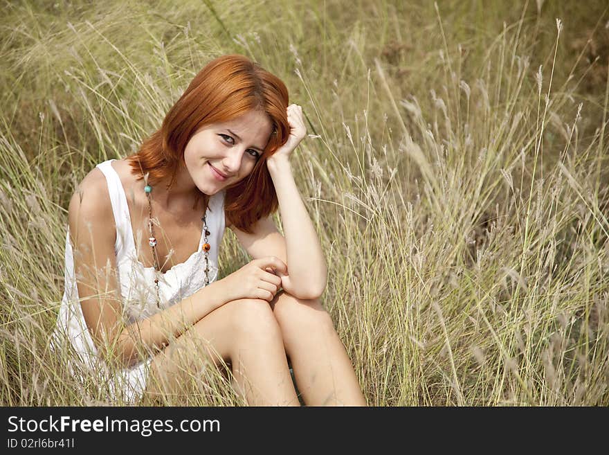 Beautiful red-haired girl at grass