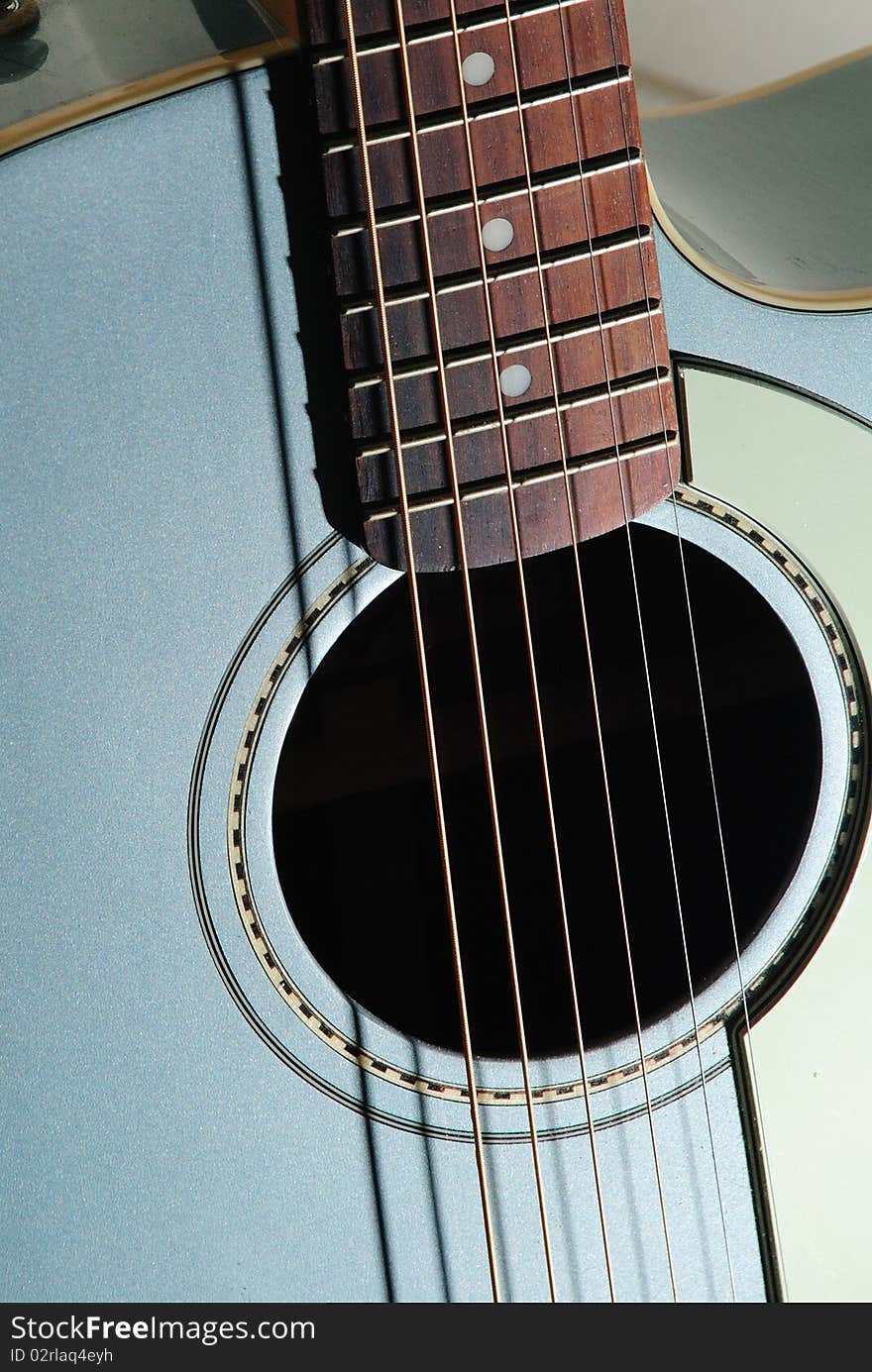 A guitar waits to be played for enjoyment of it's audience. A guitar waits to be played for enjoyment of it's audience.