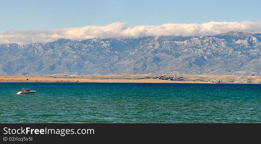 Croatian mountain range near famous town Nin, small motor-boat in foreground. Croatian mountain range near famous town Nin, small motor-boat in foreground