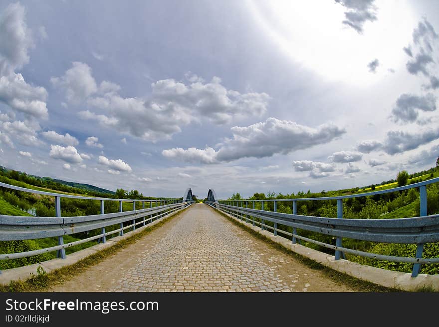 Steel bridge made with ultra wide lens - fisheye, dramatic sky above