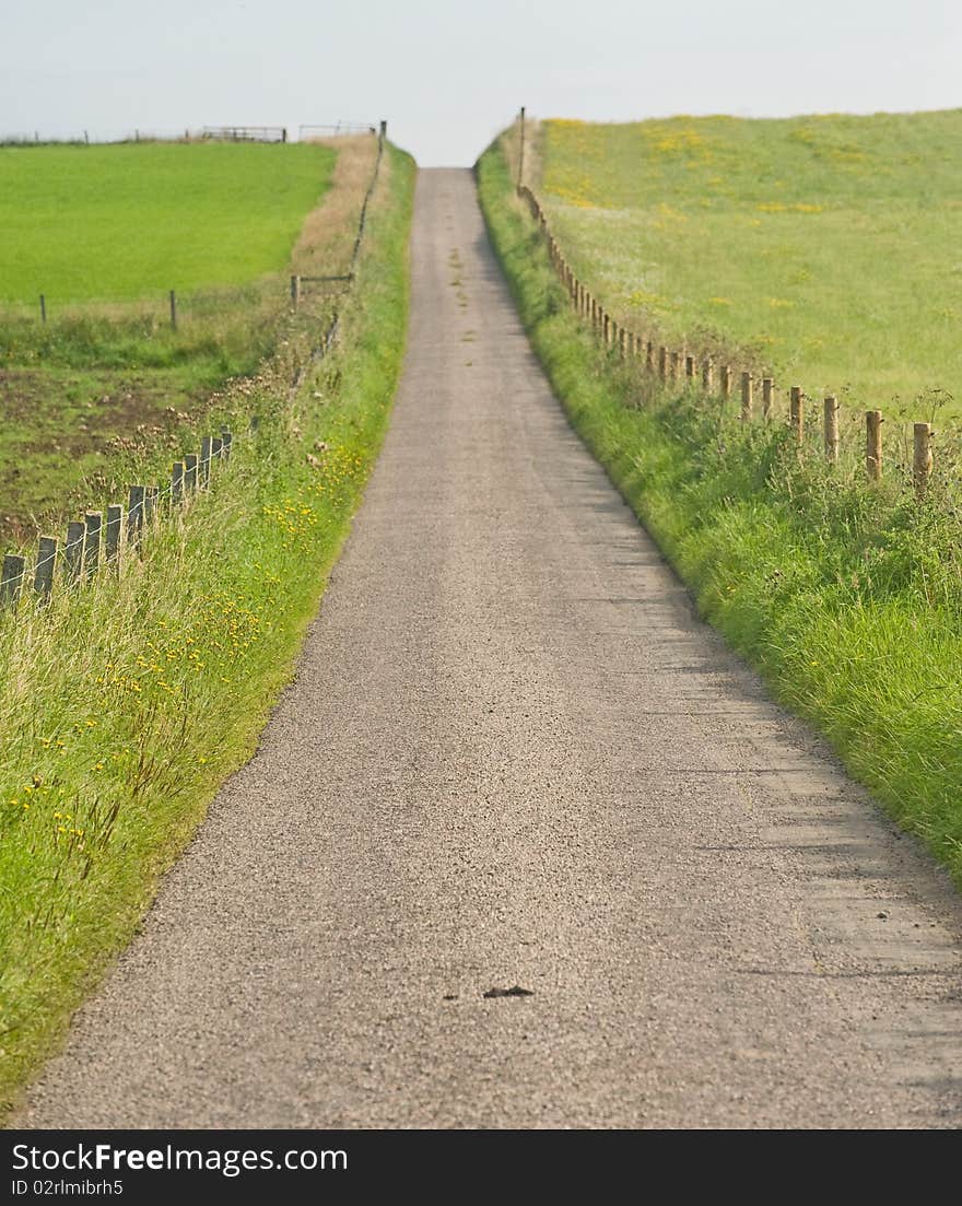 An image of a narrow country road with a summit where what is on the other side cannot be anticipated. An image of a narrow country road with a summit where what is on the other side cannot be anticipated.