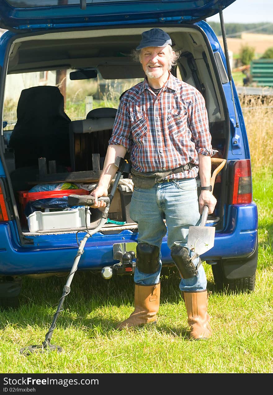 An image of a senior with a metal detector getting ready to search a field for historic artifacts. An image of a senior with a metal detector getting ready to search a field for historic artifacts.