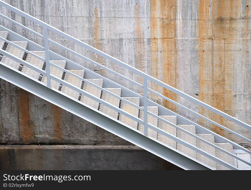 A image of ladder and hand rail, beside wall.