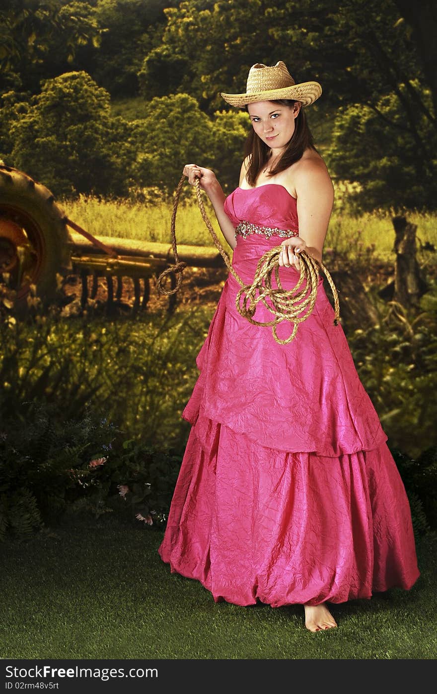 A beautiful teen in a cowboy hat and formal attire weilding a rope in a agricultural setting. A beautiful teen in a cowboy hat and formal attire weilding a rope in a agricultural setting.