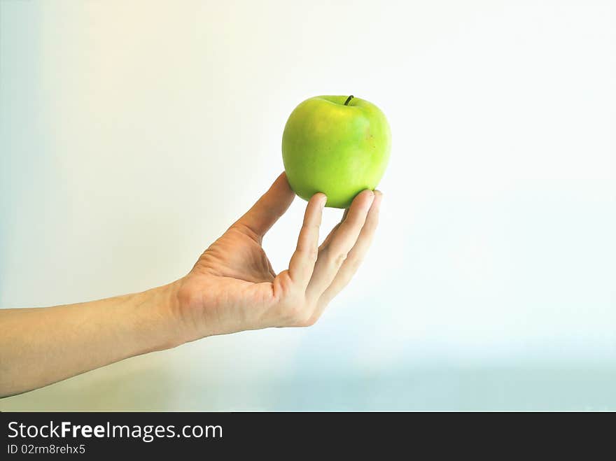 The green apple is in the fingers against colour b