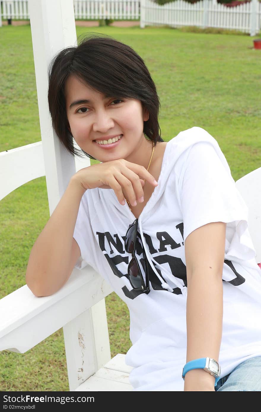 Thai Woman Sitting On A Bench