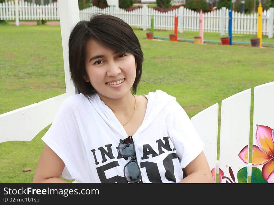 Thai cute woman sitting on a bench