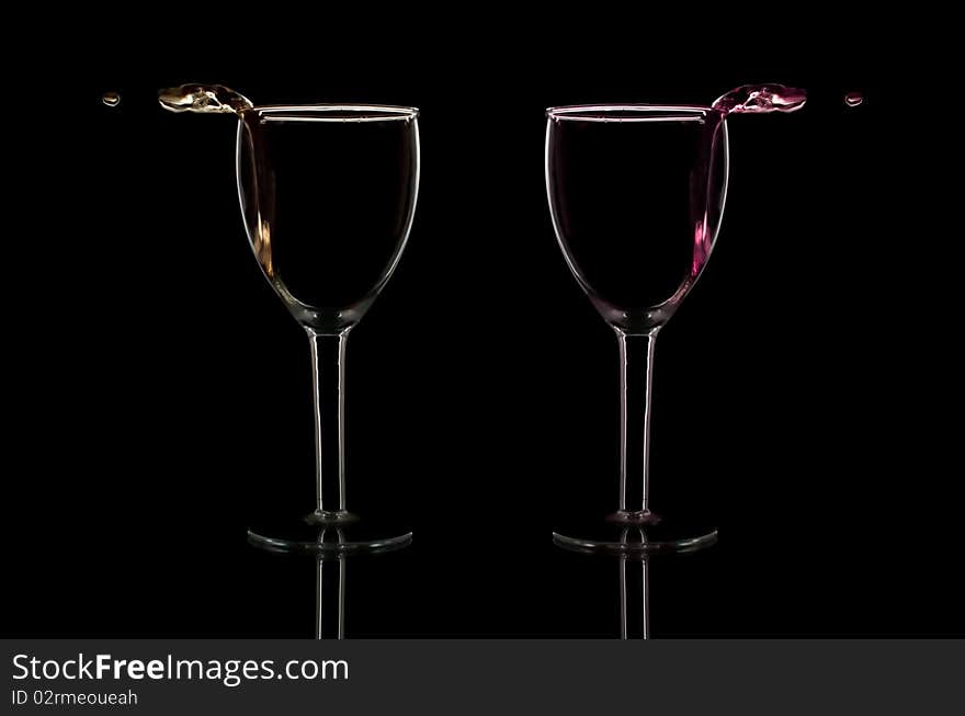 Wine pouring out of glasses isolated on black. Wine pouring out of glasses isolated on black