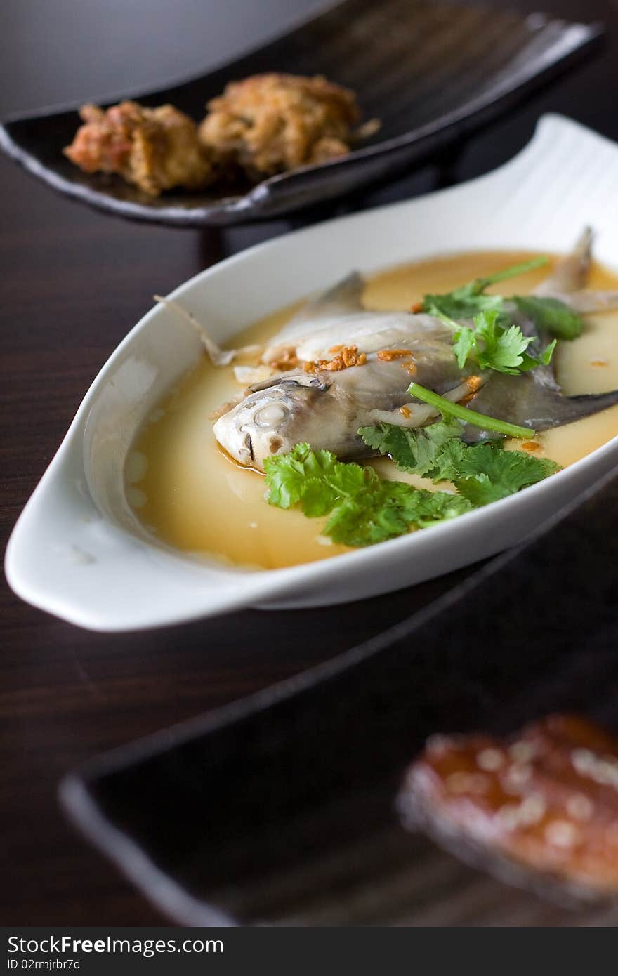 Mixed Asian Dishes served on various types of plate, placed on a brown wooden table. Mixed Asian Dishes served on various types of plate, placed on a brown wooden table