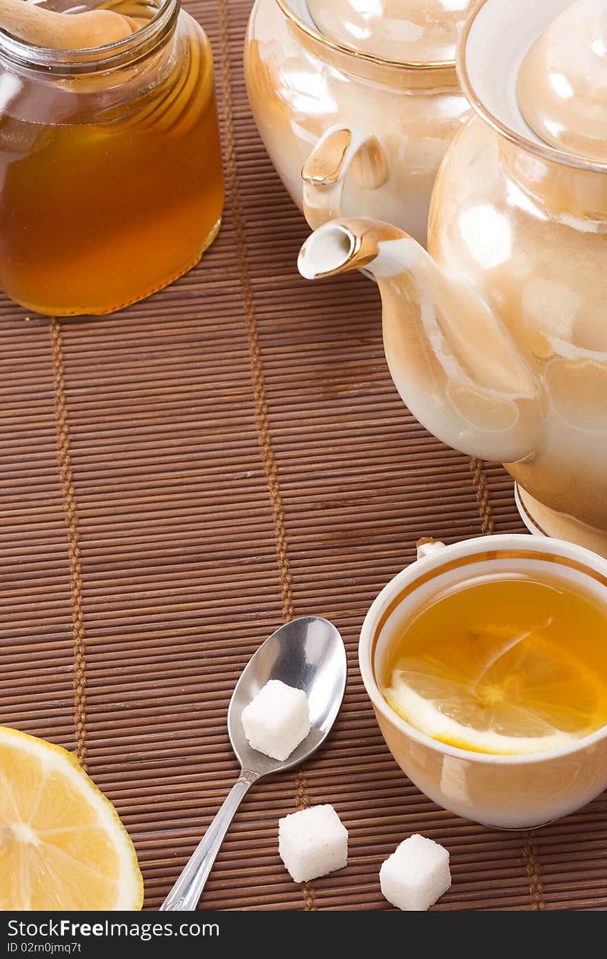 Tea, pot and honey on table