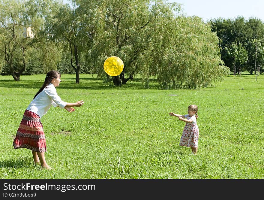 Mother and daughter playing ball on meadow. Mother and daughter playing ball on meadow