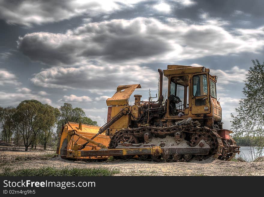 Old yellow bulldozer on nature background