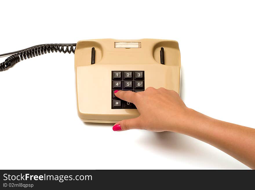 Female finger presses the button on the old phone isolated on white background. Female finger presses the button on the old phone isolated on white background.