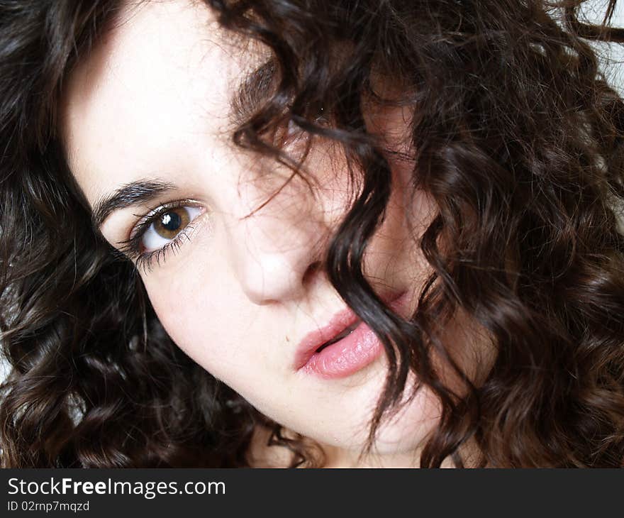 Face of a beautiful young woman with curly black hair