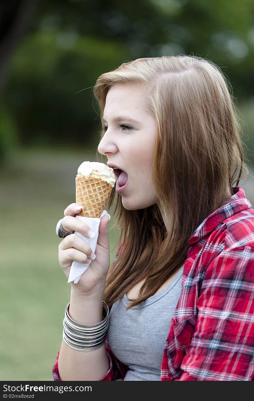 Teenage girl eating ice cream outdoors