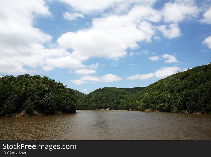 Beautiful blue cloudy sky and river with forest on the sides. Beautiful blue cloudy sky and river with forest on the sides