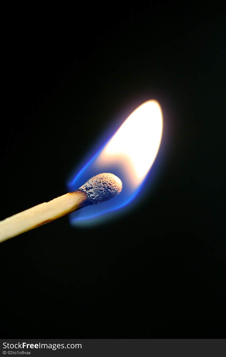 A match burns with a black background. A match burns with a black background