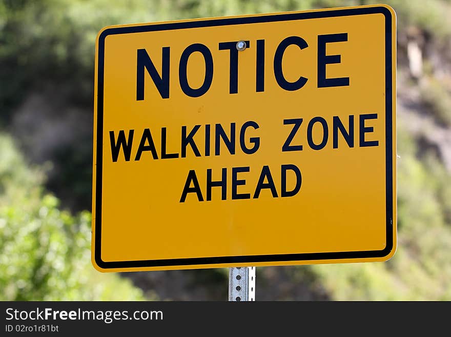 A sign letting people know it is a walking zone. A sign letting people know it is a walking zone