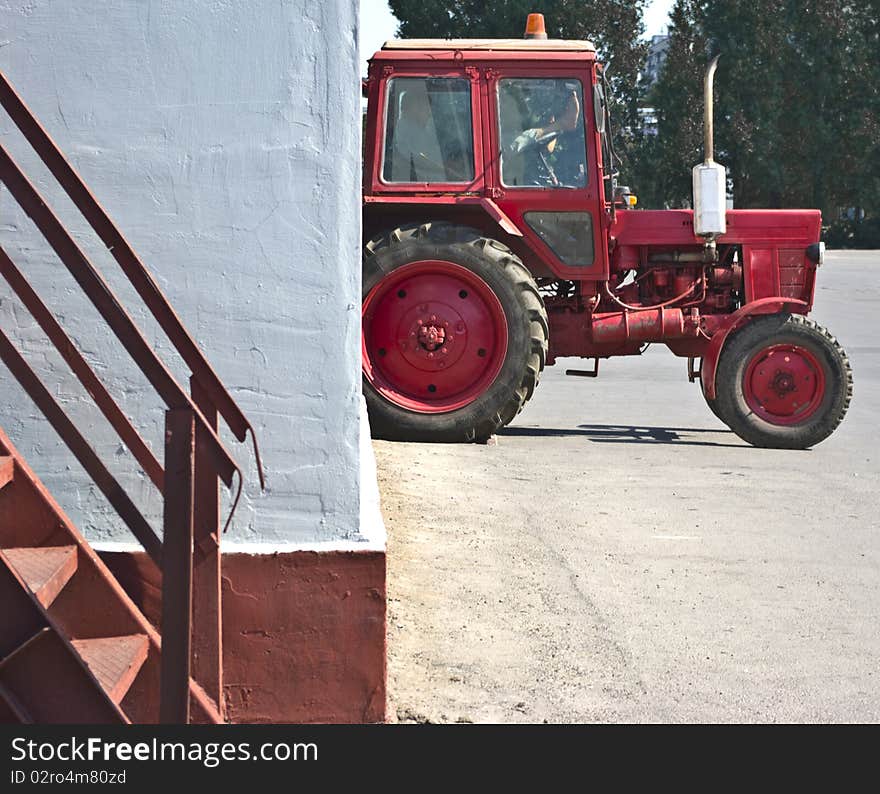 The red tractor resting in a white wall