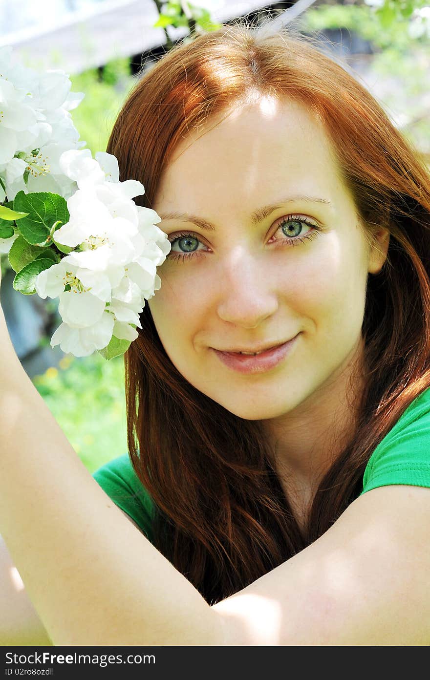 Young  woman standing at apple tree in white blossom. Young  woman standing at apple tree in white blossom