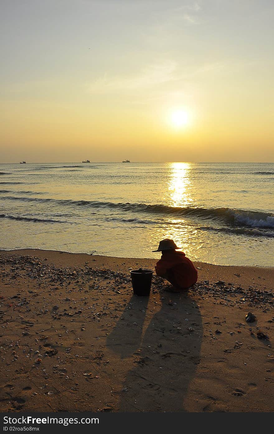 Sunrise and old woman at Cha-am Beach ,Thailand