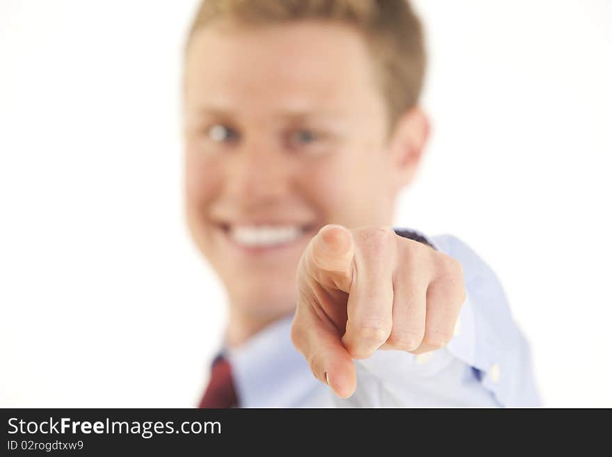 Portrait of smiling young businessman pointing finger at camera