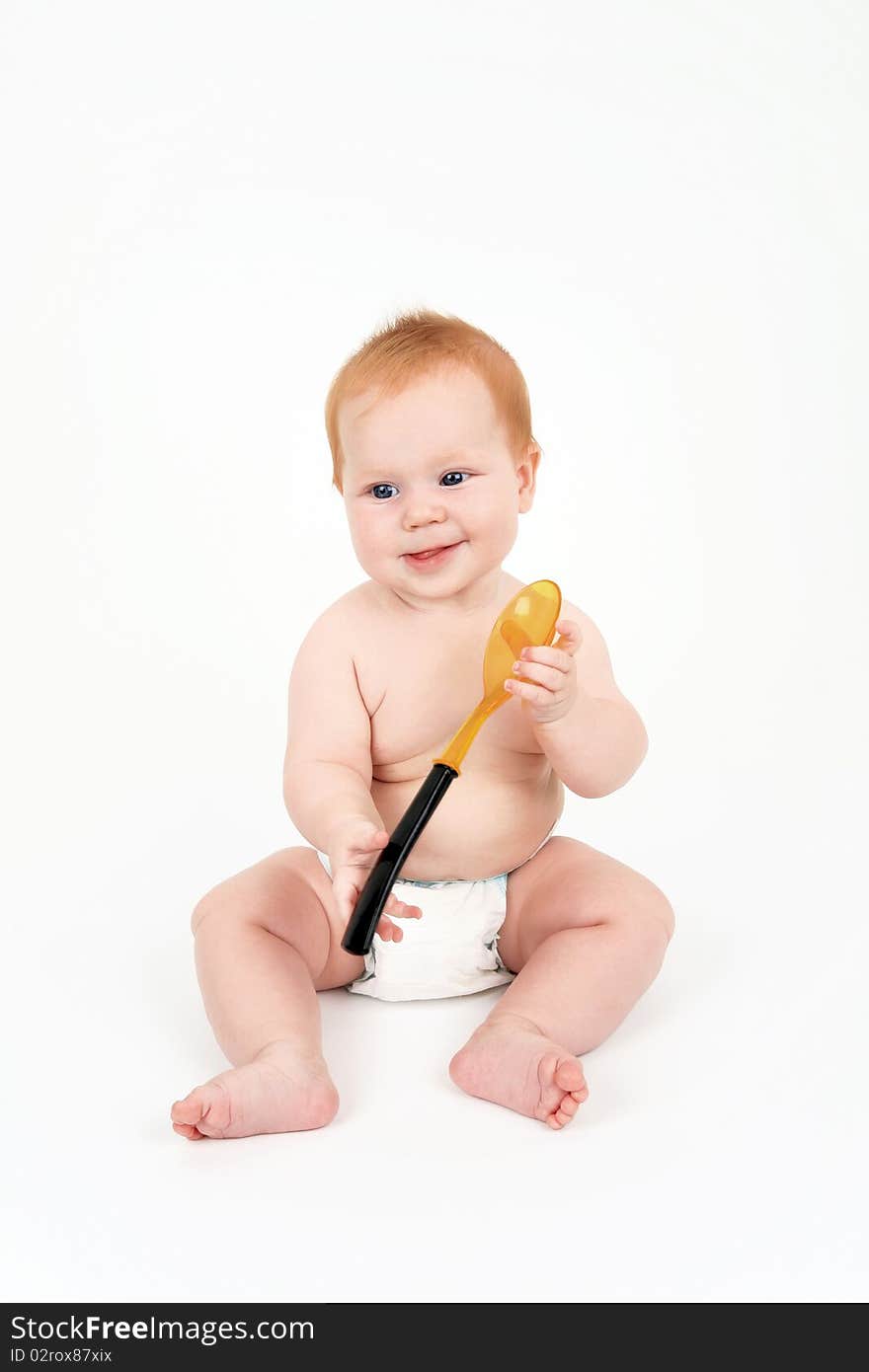 The child with a spoon in hands on a white background