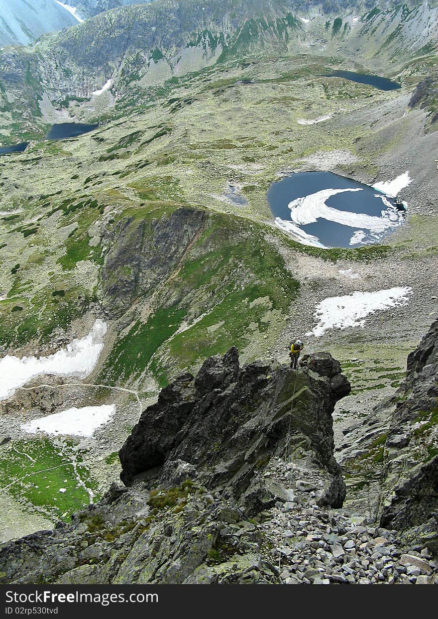 Mountaineer abseiling into alpine valley, High Tatras, Slovakia. Mountaineer abseiling into alpine valley, High Tatras, Slovakia