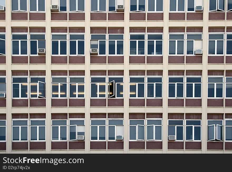 A straight flat view of an office building with windows.