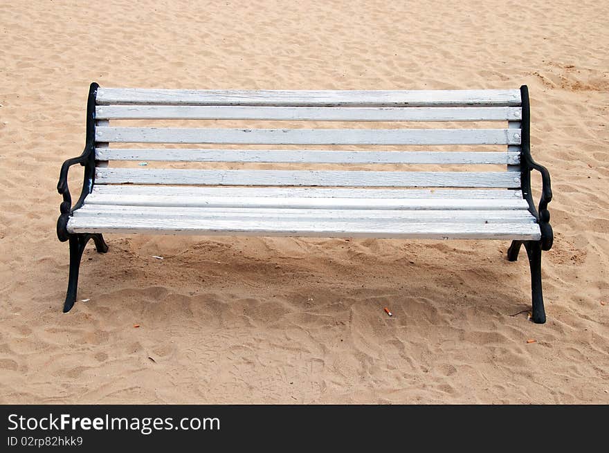 Wooden bench and butts over the sand