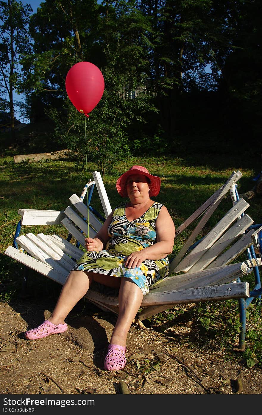 The woman with a balloon, sitting on a bench. The woman with a balloon, sitting on a bench