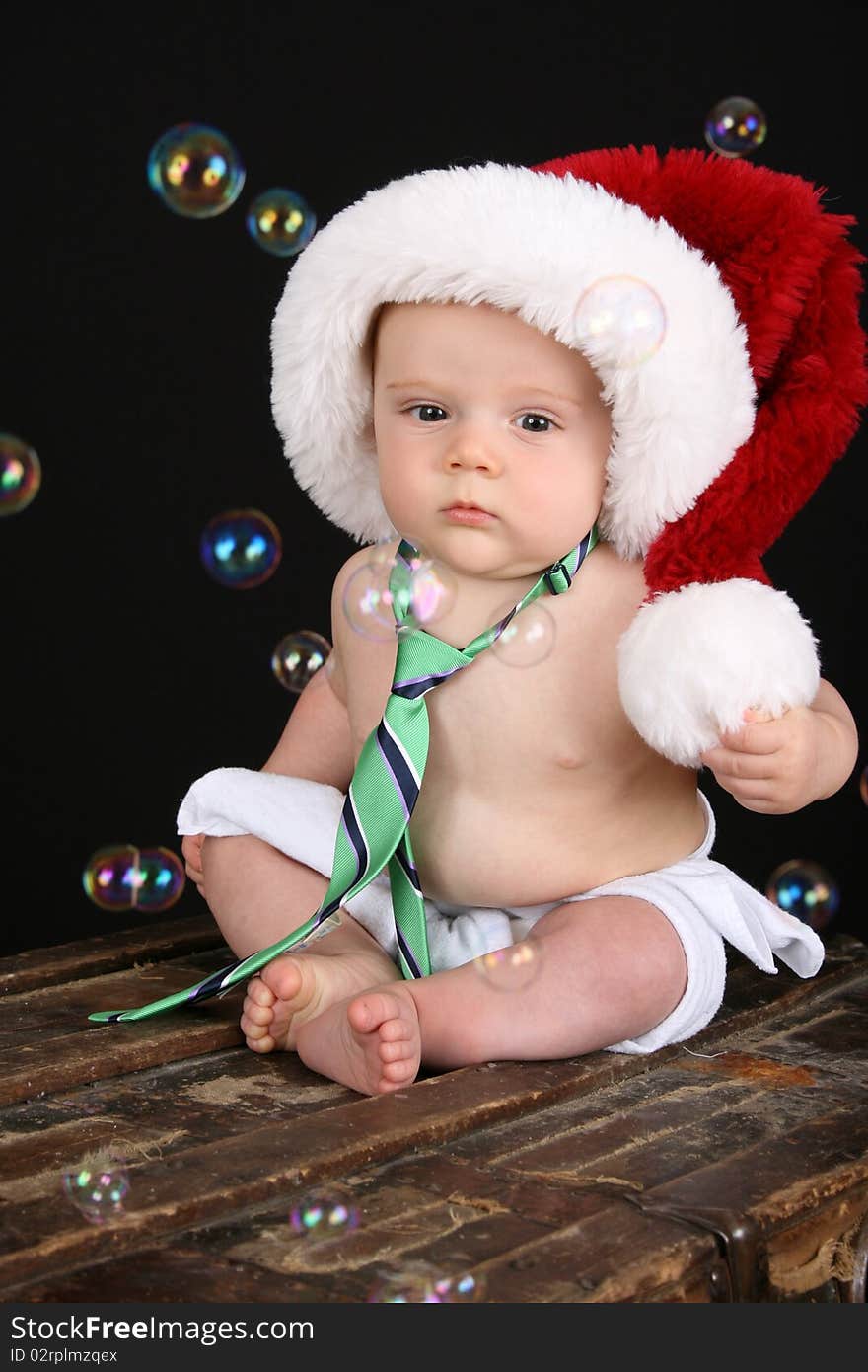 Cute christmas baby boy sitting on an antique trunk