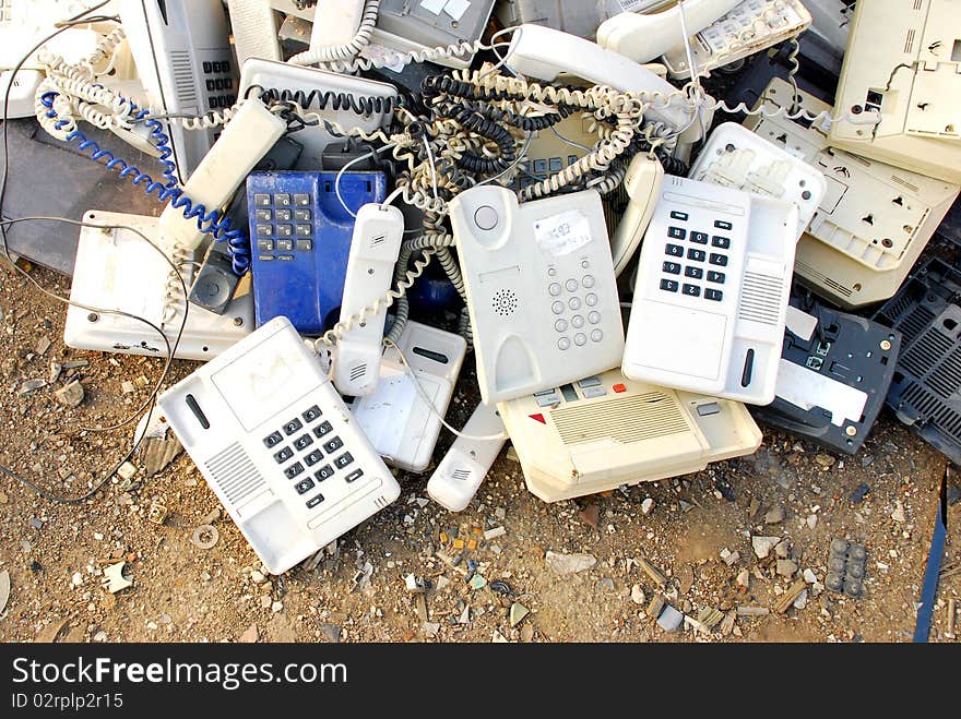 Stack of old broken telephones on the ground. Stack of old broken telephones on the ground