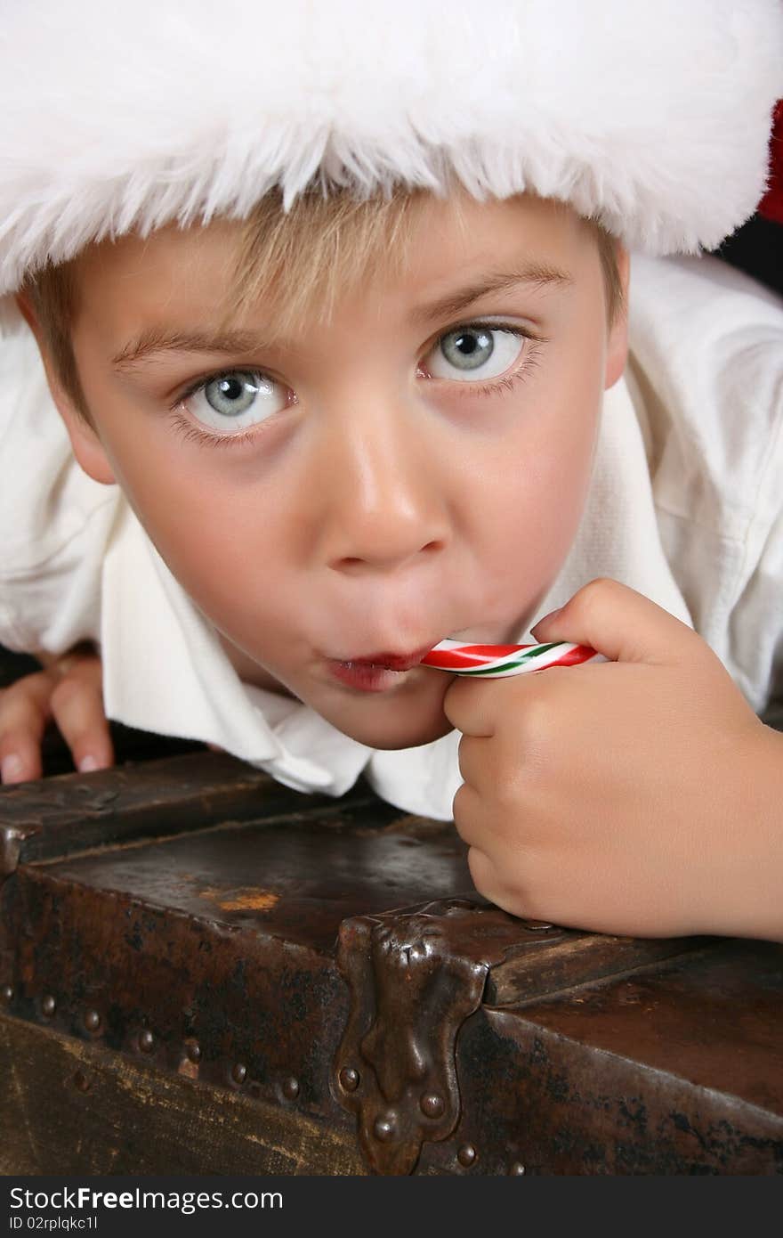 Close up of christmas boy eating a candy cane